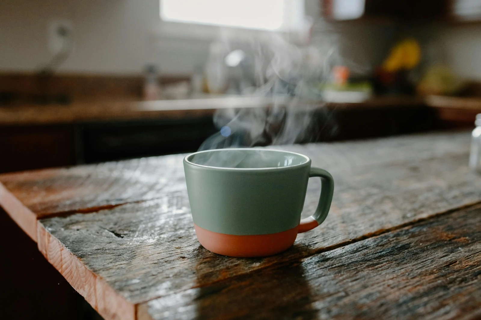 Mug fumant sur table en bois — moment cocooning à la maison